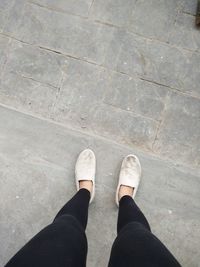 Low section of woman standing on road