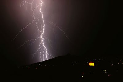 Low angle view of illuminated ferris wheel at night