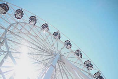 Low angle view of ferris wheel against clear blue sky