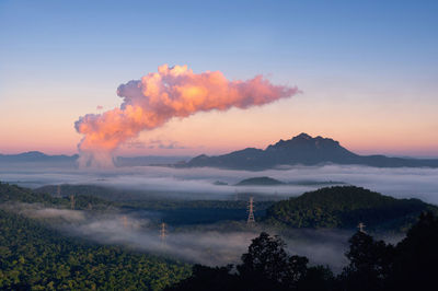 Fog in the forest, high voltage pole and steam from coal power plant. mae moh, lampang, thailand. 