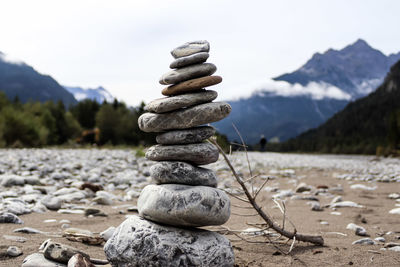 Stack of stones on rock against sky