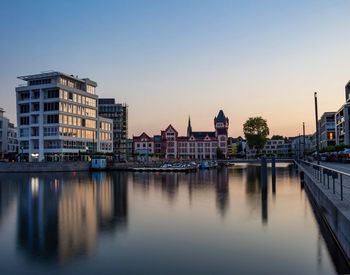 Reflection of buildings in river against sky