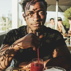 Portrait of man having drink at restaurant