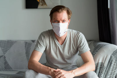 Portrait of man sitting on sofa at home