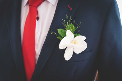 Midsection of bridegroom with flower in pocket
