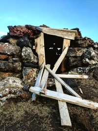 Stack of abandoned wood against clear sky