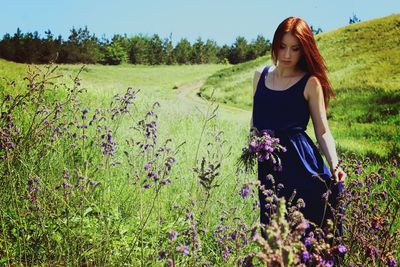 Young woman on field against sky