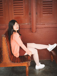 Portrait of a smiling young woman sitting outdoors