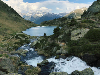 Scenic view of river amidst mountains against sky