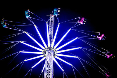 Low angle view of illuminated ferris wheel against sky at night