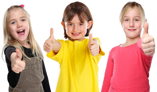 Portrait of happy girl standing against white background