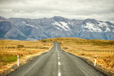 Road amidst mountains against sky