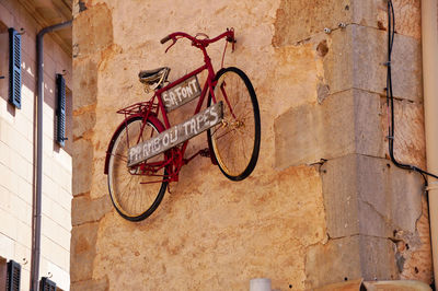 Bycycle hanging as a sign on a wall