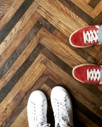 Low section of man standing on hardwood floor