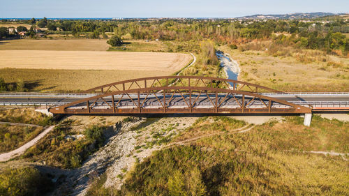 Bridge over field against trees