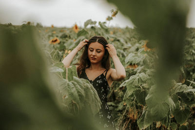 Young woman standing at sunflower farm