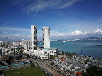 High angle view of city by sea against sky