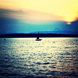 Boat sailing in sea at sunset