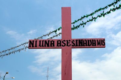 Low angle view of road sign against sky