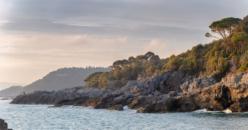 Scenic view of sea and mountains against sky