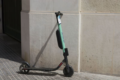 Bicycle on footpath against wall