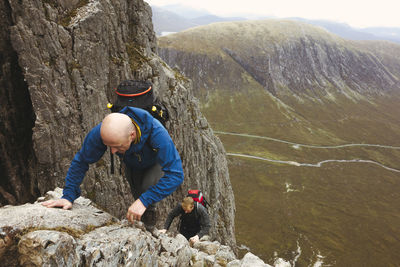 High angle view of men climbing on rocky mountain