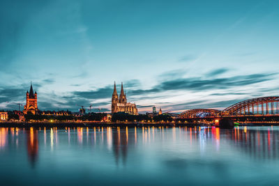 Panoramic view of cologne cathedral with hohenzollern bridge at nightfall, germany.