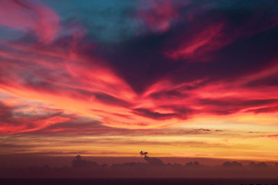 Scenic view of dramatic sky over silhouette landscape
