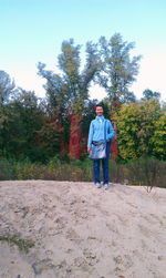 Full length of man standing by tree against sky