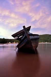 Boat moored on river against sky