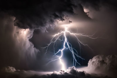 Low angle view of lightnings  between clouds at night