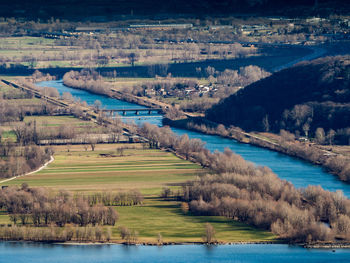 Scenic view of river by trees on field