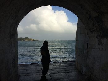 Silhouette of man standing on sea shore