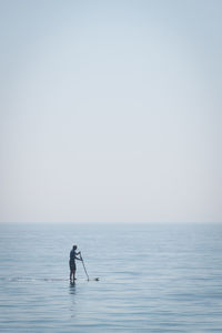 Man in sea against clear sky