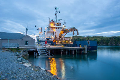 Commercial fishing boat in harbour. isle of skye, scotland. morning. lights reflected in the water.