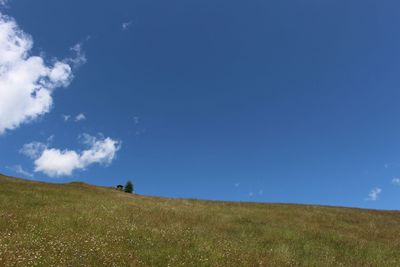 Scenic view of grassy field against cloudy sky