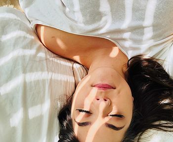 Directly above shot of young woman sleeping on bed