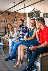 Office workers team talking sitting over the table in coworking