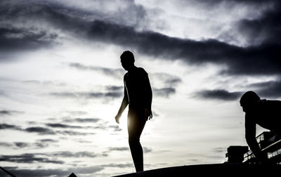 Silhouette of man standing against cloudy sky