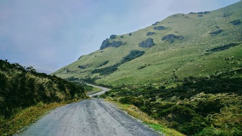 Road amidst trees against sky