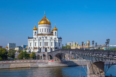 Bridge over river against buildings in city