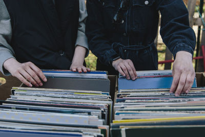 Midsection of gay women selecting record at market stall