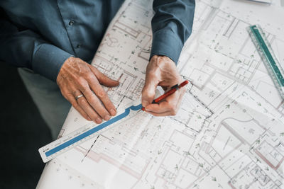 High angle view of man working on blueprint