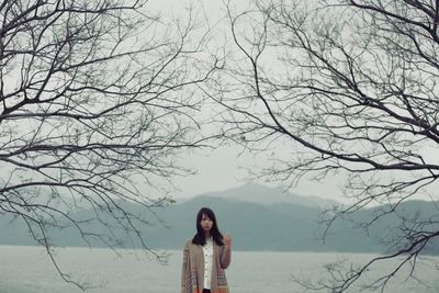 Silhouette of woman standing on tree trunk