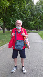 Full length portrait of smiling woman standing on sidewalk