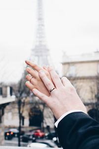 Close-up of couple hands against eiffel tower