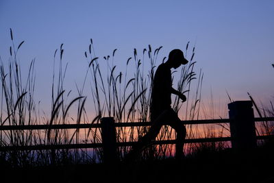 Silhouette woman standing against clear sky during sunset