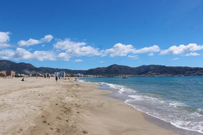 Scenic view of beach against blue sky