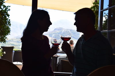 Smiling couple drinking red wine at restaurant