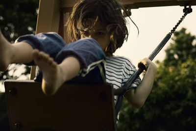 Girl playing on swing at playground